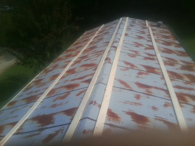 Rusted metal roof panels with new wood purlins before replacement — Storm Damage Roof Repair in Furlong by Roofing Brothers