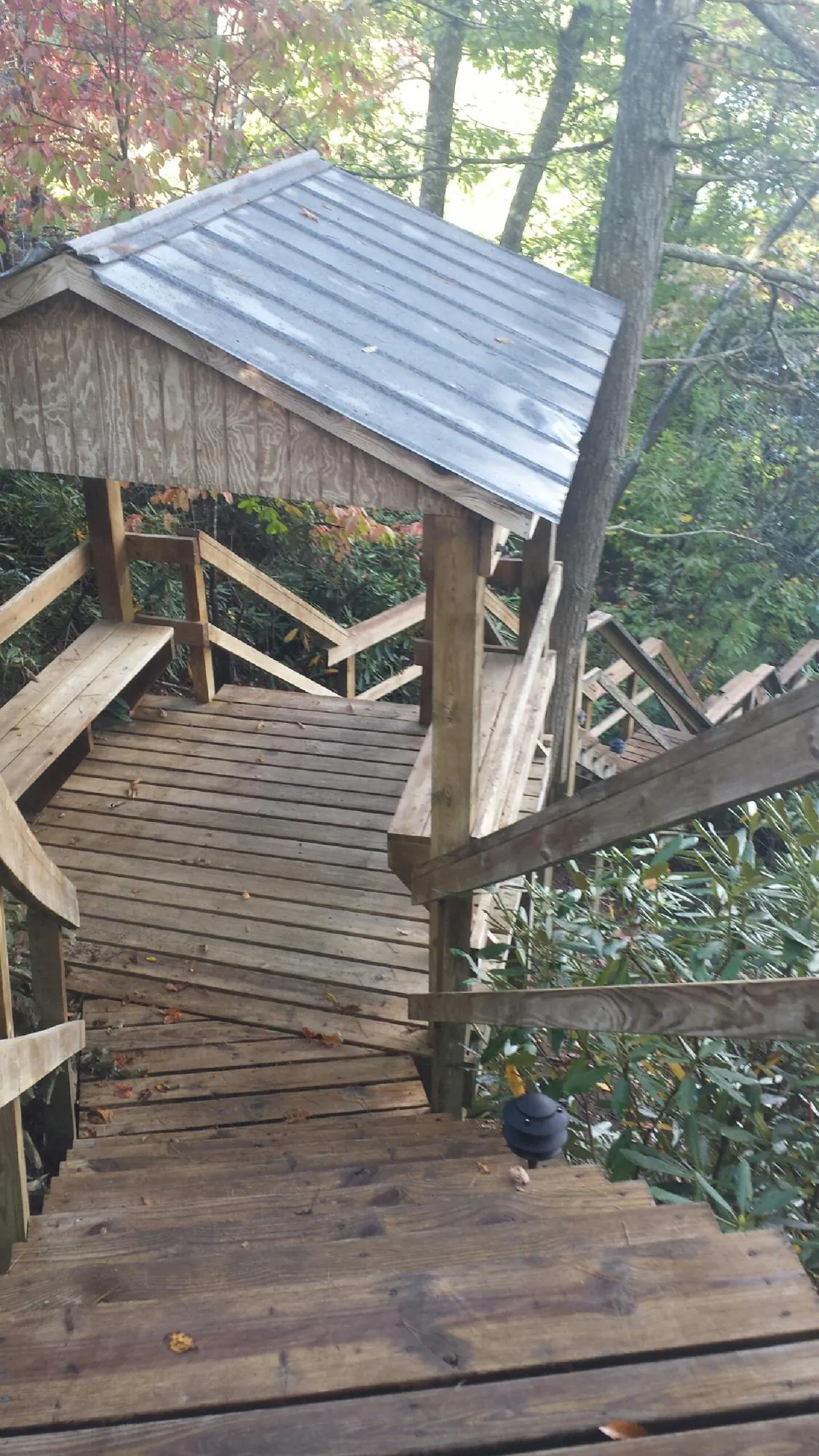 Metal roofed shelter over wooden steps on a wooded walkway — Skylight Repair & Installation work by our crew in Furlong
