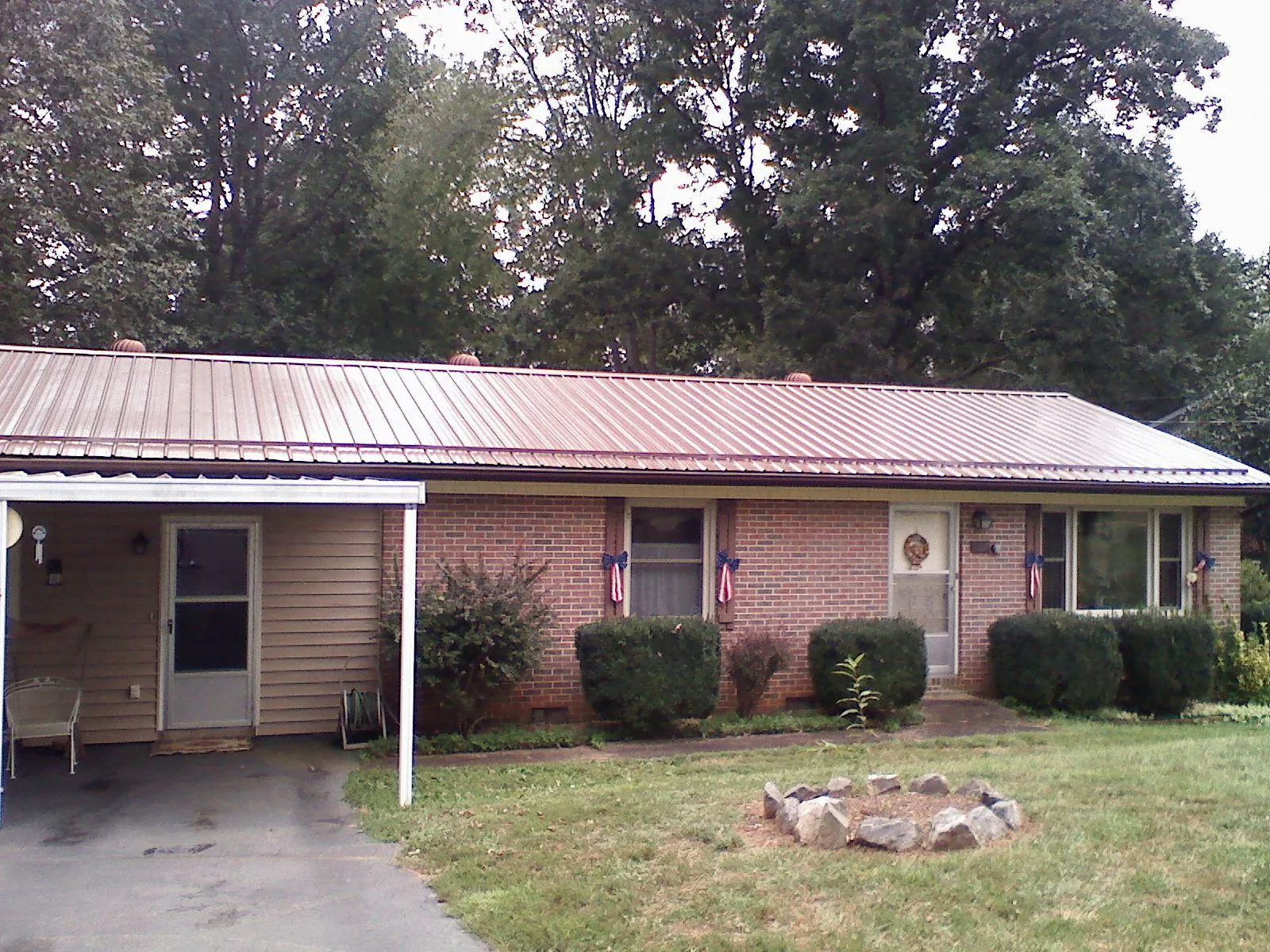 Bronze metal roof and carport on a brick ranch home — Roof Repair work by our crew in Furlong